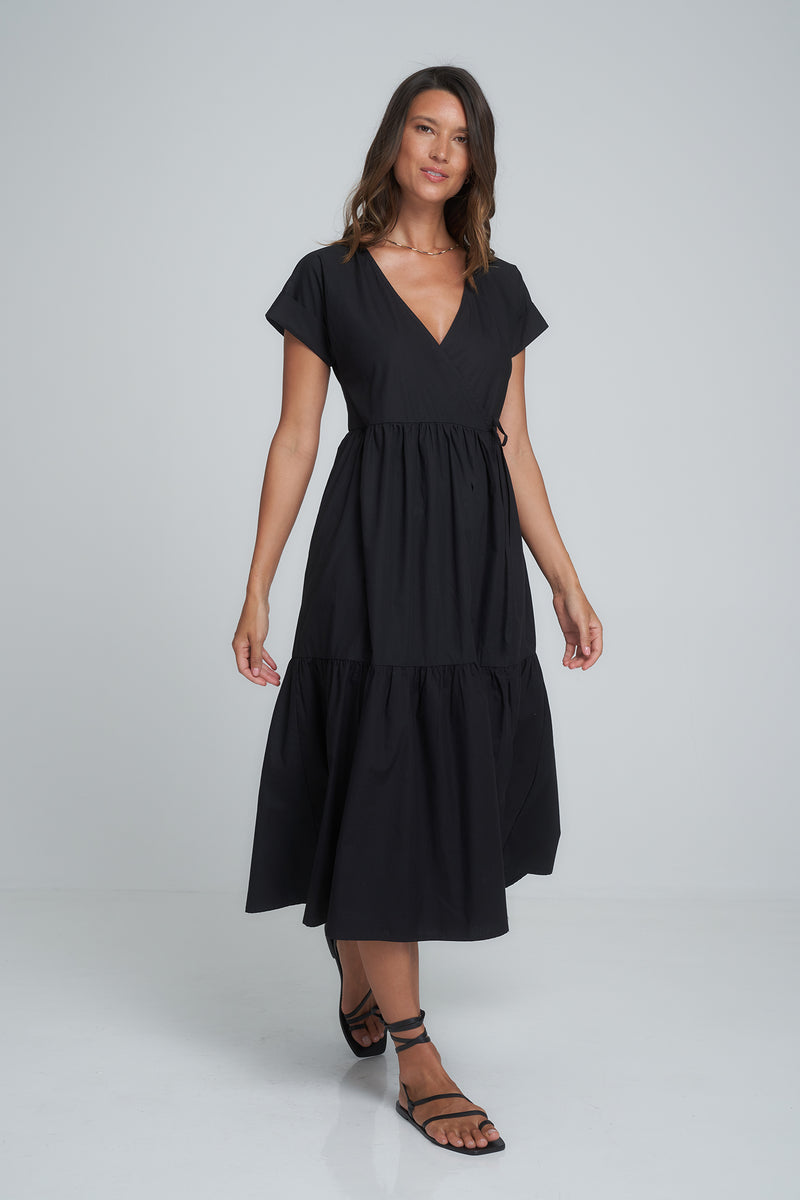 A model wearing a black cotton maxi wrap dress