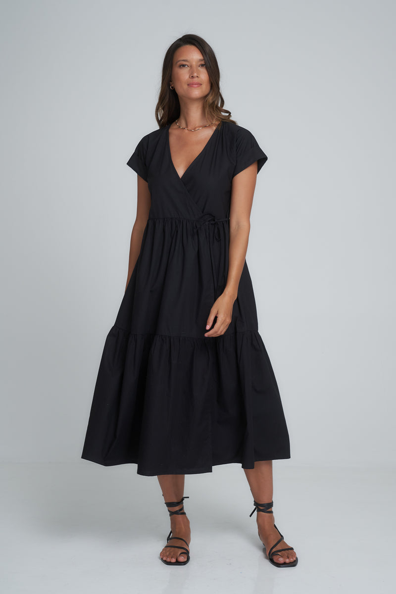 A model wearing a classic black cotton maxi wrap dress
