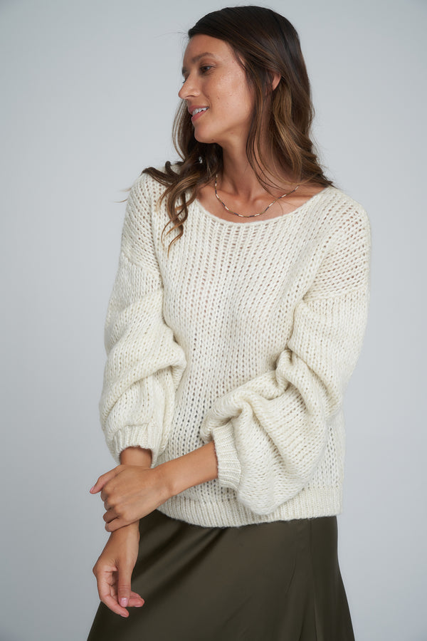 A model wearing a white knit jumper by LILYA