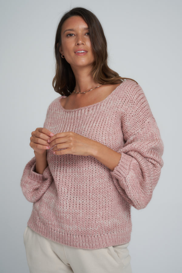 A woman wearing a pink classic knit jumper
