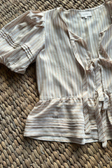 Tie front top with peplum hem and pintuck detail