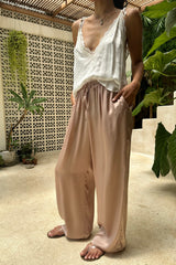 Person wearing a white top and pink pants 