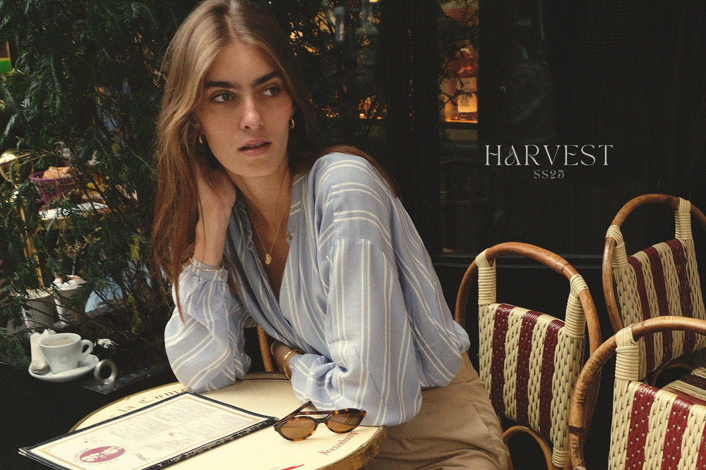 Woman sitting at a table in a cafe with 'Harvest' branding.