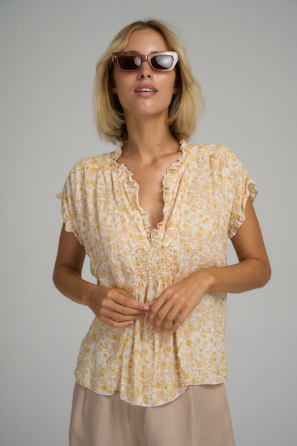 A model wearing a yellow floral summer top