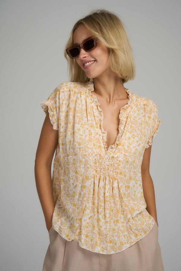 A model wearing a yellow cotton floral top