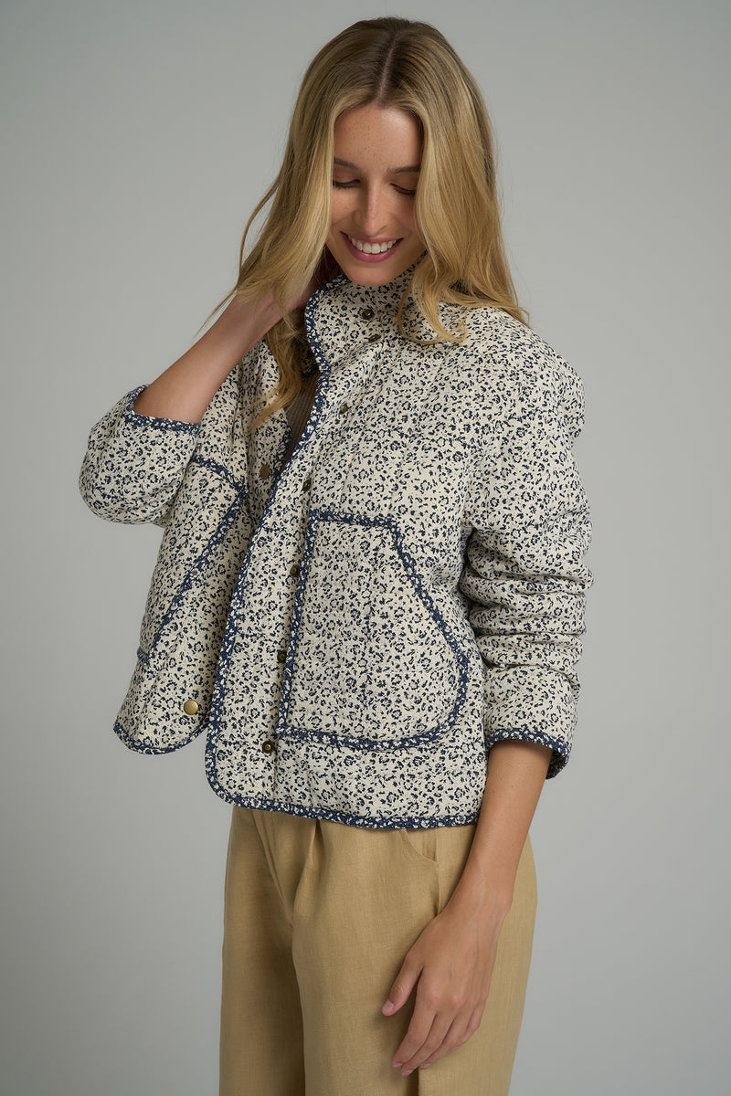 A model wearing a white and blue floral jacket