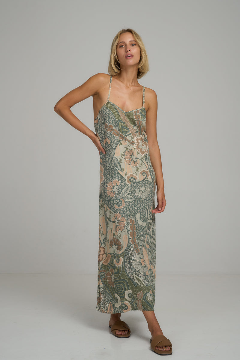 A woman wearing a summer green floral maxi dress