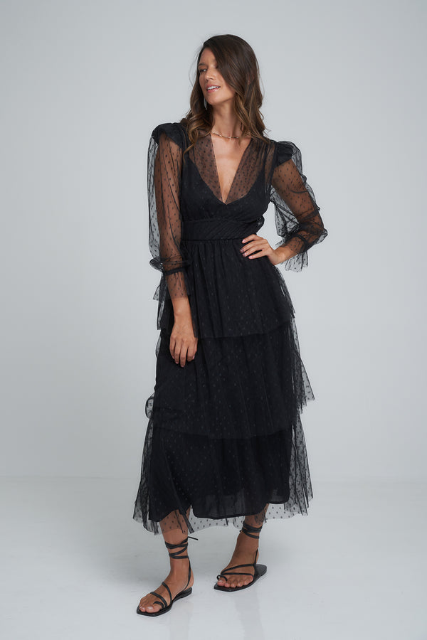 A model wearing a black lacey dress by LILYA