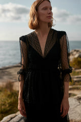 A model wearing a black lace elegant dress
