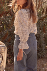 Back photo of a woman wearing the Mohave Blouse in textured linen-cotton blend with frill detail on the sleeve. 