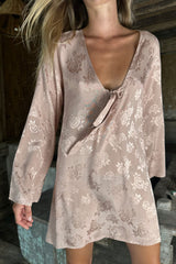 Model wearing the silky satin mini dress in pink jacquard with a tie up front detail.