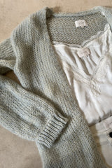 Flat lay image of a blue marle knit cardigan