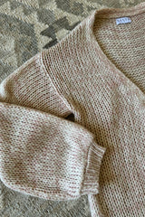 An image of a light pink cardigan