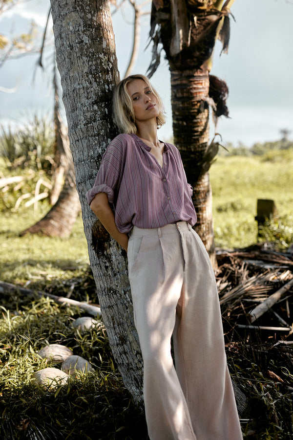 A model wearing light pink linen pants