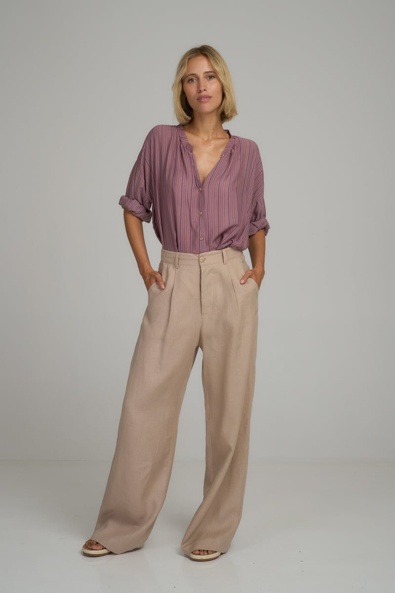 A model wearing light pink linen pants