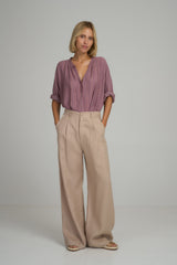 A model wearing natural linen high rise pants