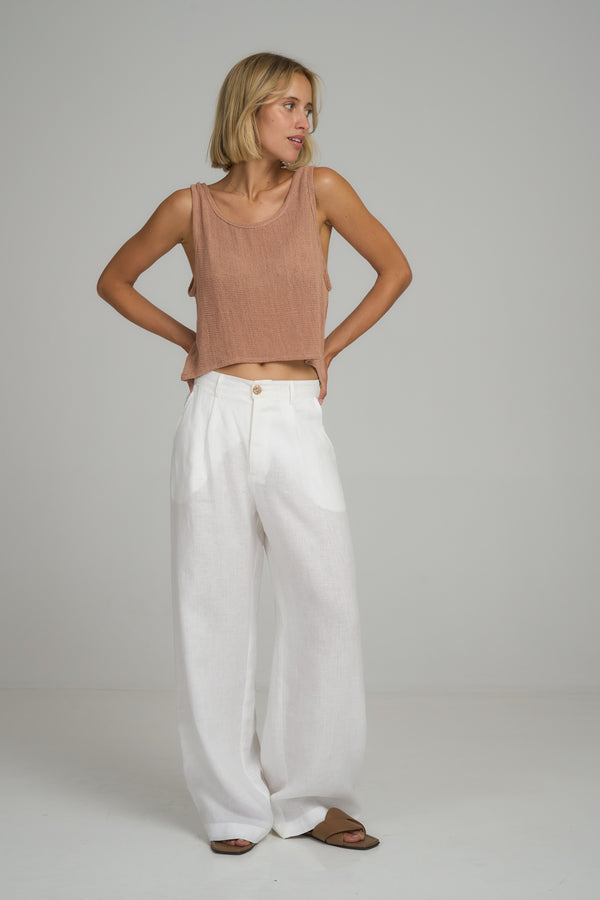 A woman wearing classic white linen pants