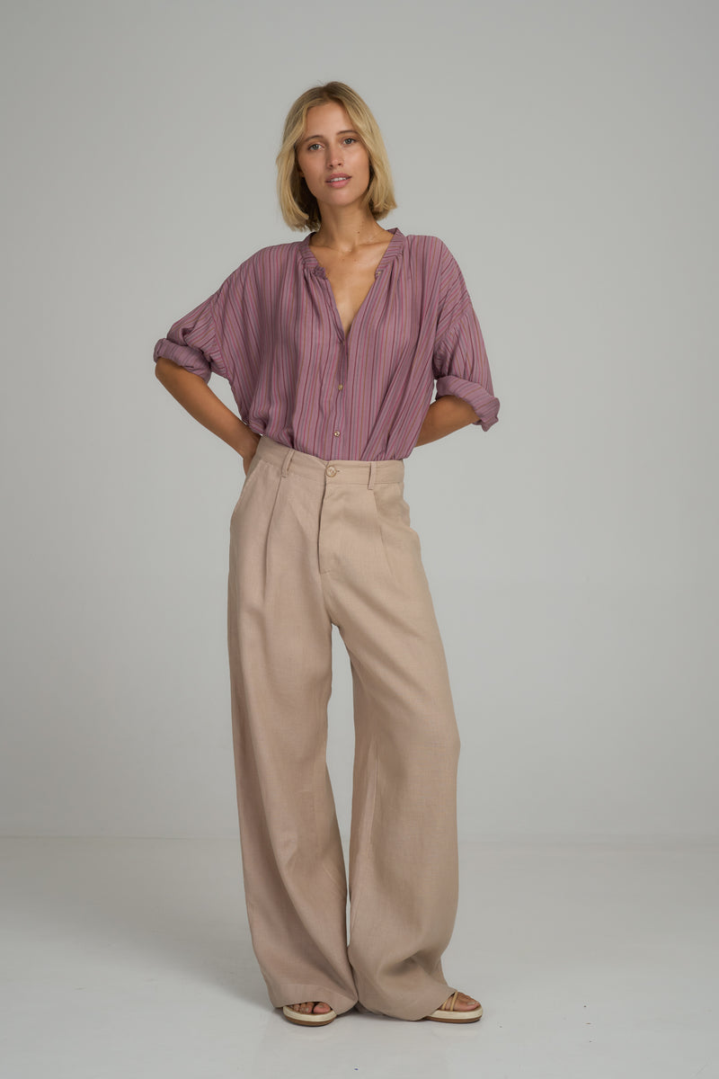 A woman wearing light pink linen dress pants