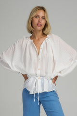 A model wearing a white textured cotton blouse