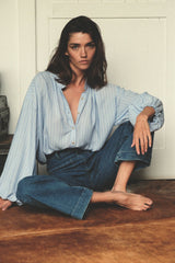 Model wears blue stripe blouse styled with denim jeans by LILYA