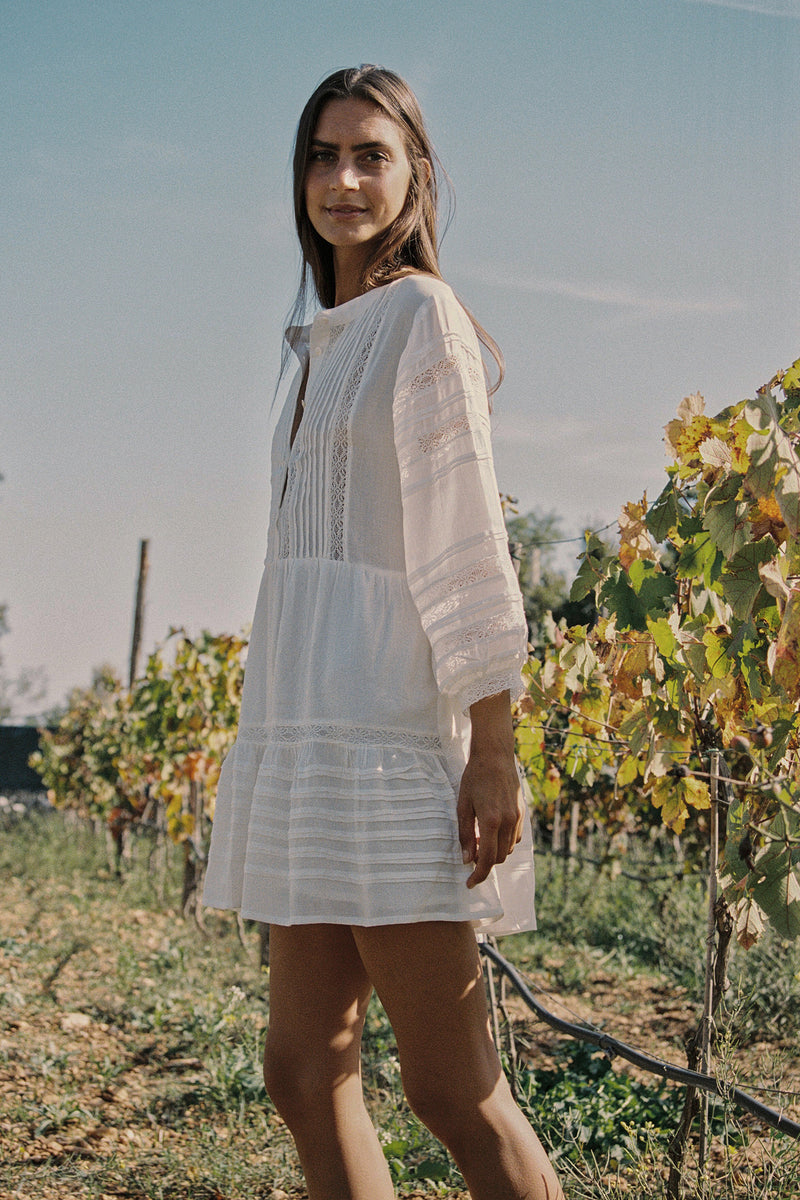 A model wearing a white cotton lace mini dress