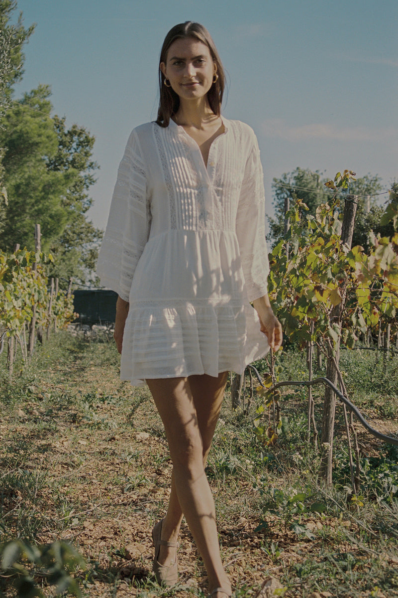 A model wearing a white lace mini dress