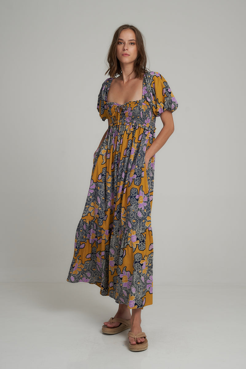 A Model Wearing a Bold Batik Floral Tiered Maxi Dress