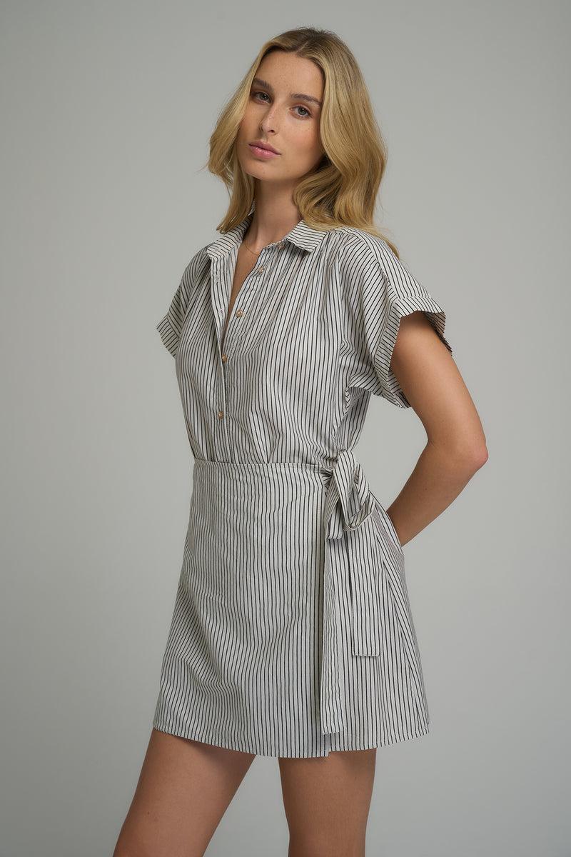 A woman wearing a black and white mini wrap dress