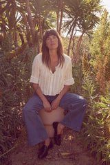 Olivia wearing the Sonora Top in White with the Lou Lou jeans in her garden in California.