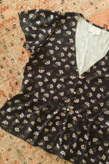 Flat lay of the navy floral blouse from the JKB X LILYA collaboration. 