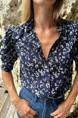 Detail of the button front neckline and puff sleeves of the Woodford shirt by LILYA. 