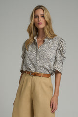 A model wearing a white and blue floral blouse