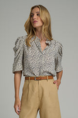 A model wearing a navy and white floral dress shirt