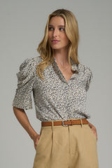 A model wearing a floral blouse with puff sleeves