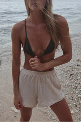Natural mesh shorts with practical side pockets, styled with bikini