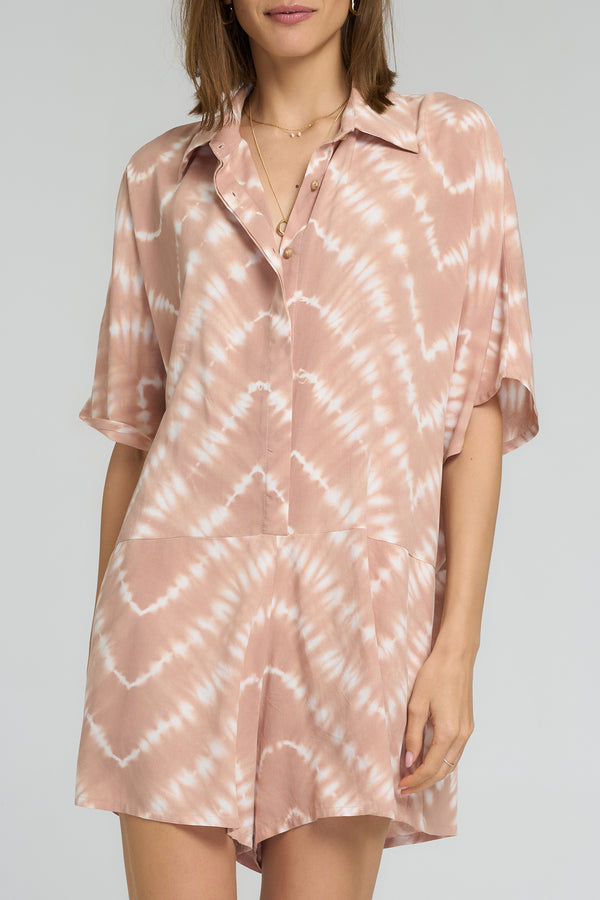 Close-up of tie dye pattern in guava hues on playsuit fabric