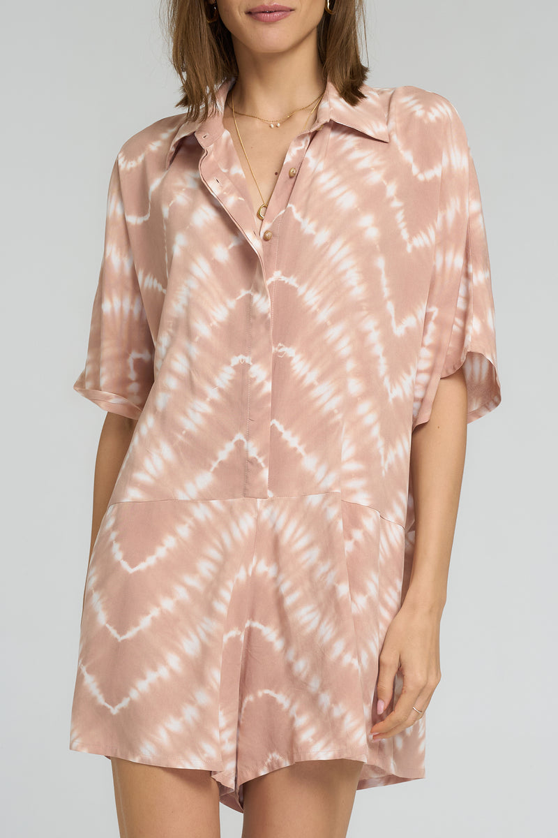 Close-up of tie dye pattern in guava hues on playsuit fabric