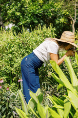 Jess in her garden wearing the high-rise wide-leg denim jeans from the JKB X LILYA Collaoration.