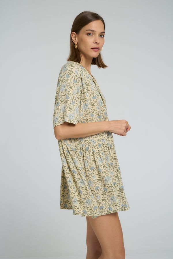 Side profile of woman in loose-fitting boho floral mini dress