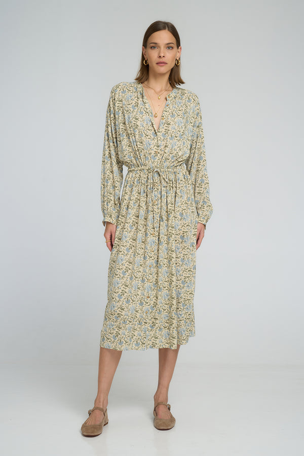 Model wearing floral Ginger Shirt Dress with rolled sleeves and elastic waist, midi length