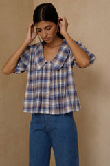 Feminine plaid blouse styled casually with relaxed denim jeans 