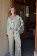 Model wears a silky green satin set by LILYA. 