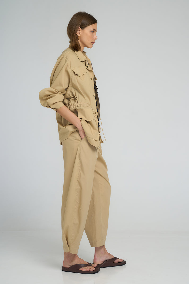 Close-up of ankle press-stud detail on sand utility pants