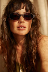 Woman wearing sunglasses with a warm, soft focus background