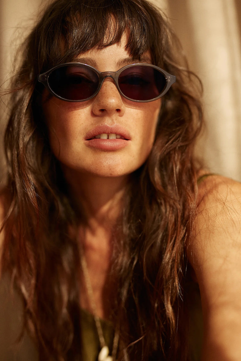 Woman wearing sunglasses with a warm, soft focus background