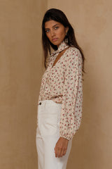 Romantic floral blouse styled casually with relaxed white pants