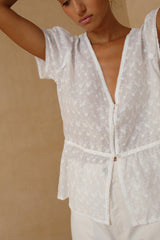 Soft feminine white top paired with relaxed pants