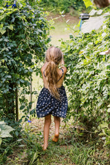 Lila Kids Dress in Yarrow Navy with crossover straps and a pinafore silhouette.