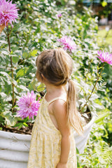 Side view on the Lila kids dress in a yellow floral print. 