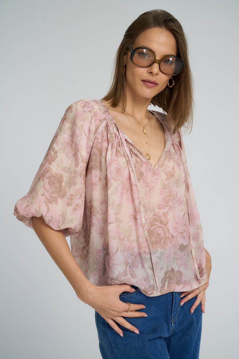 Model wearing the Etta Top by LILYA in a muted floral print with puff sleeves